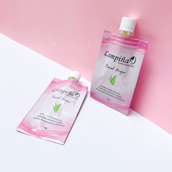 Dos sobres de Crema Depilatoria Facial Lampiña de 15 g sobre una superficie blanca y rosada