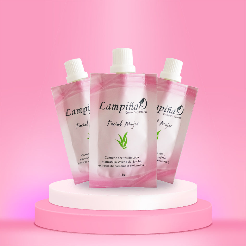 Tres sobres rosados de Crema Depilatoria Facial Lampiña de 15 g sobre un pedestal blanco con fondo rosado